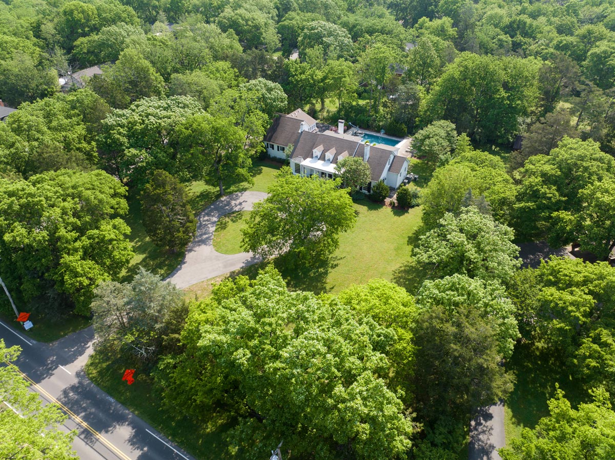 Aerial view of a wooded Middle Tennessee property with a private pool