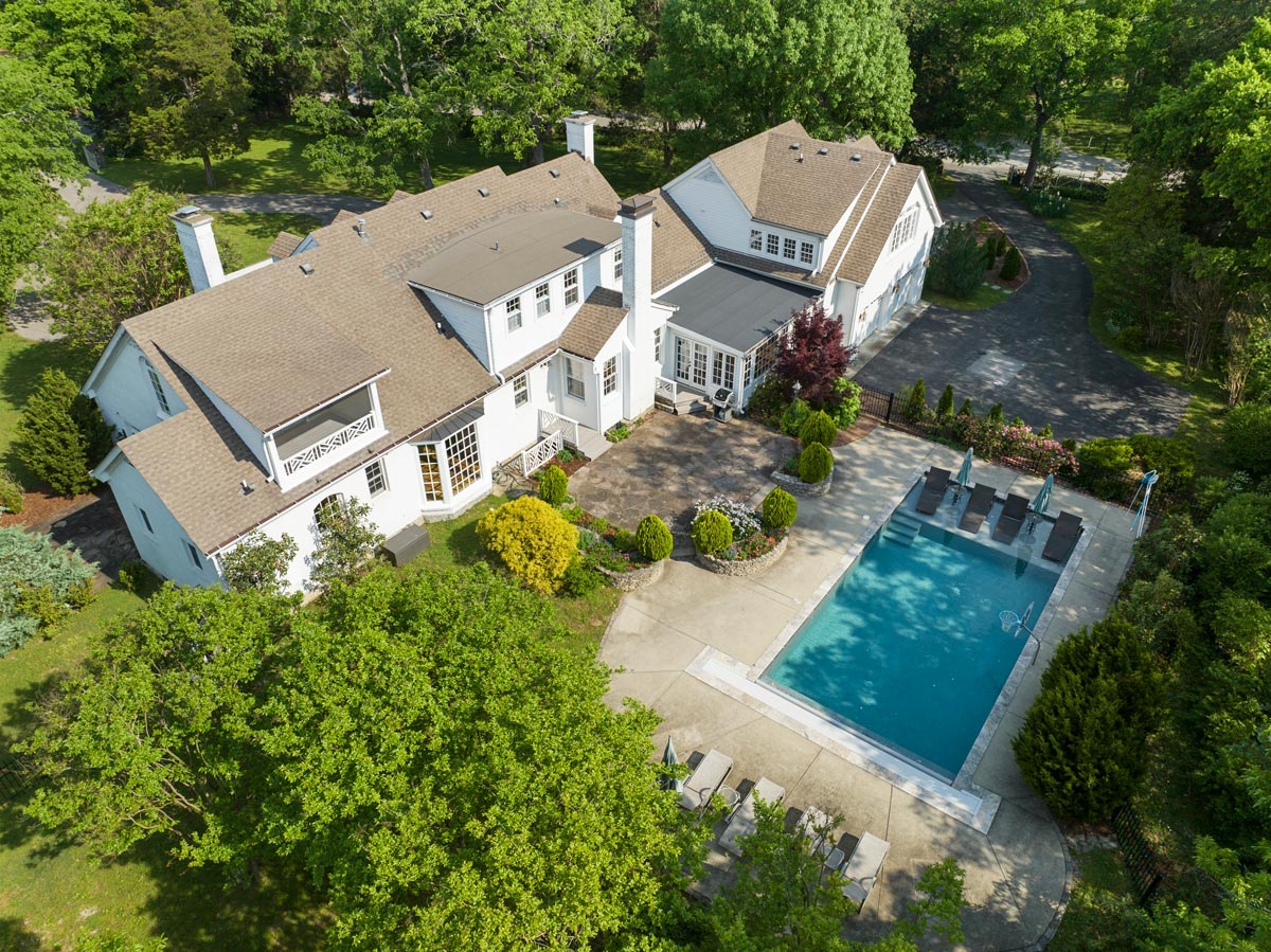 Aerial view of a Nashville, TN home with a large backyard pool and patio
